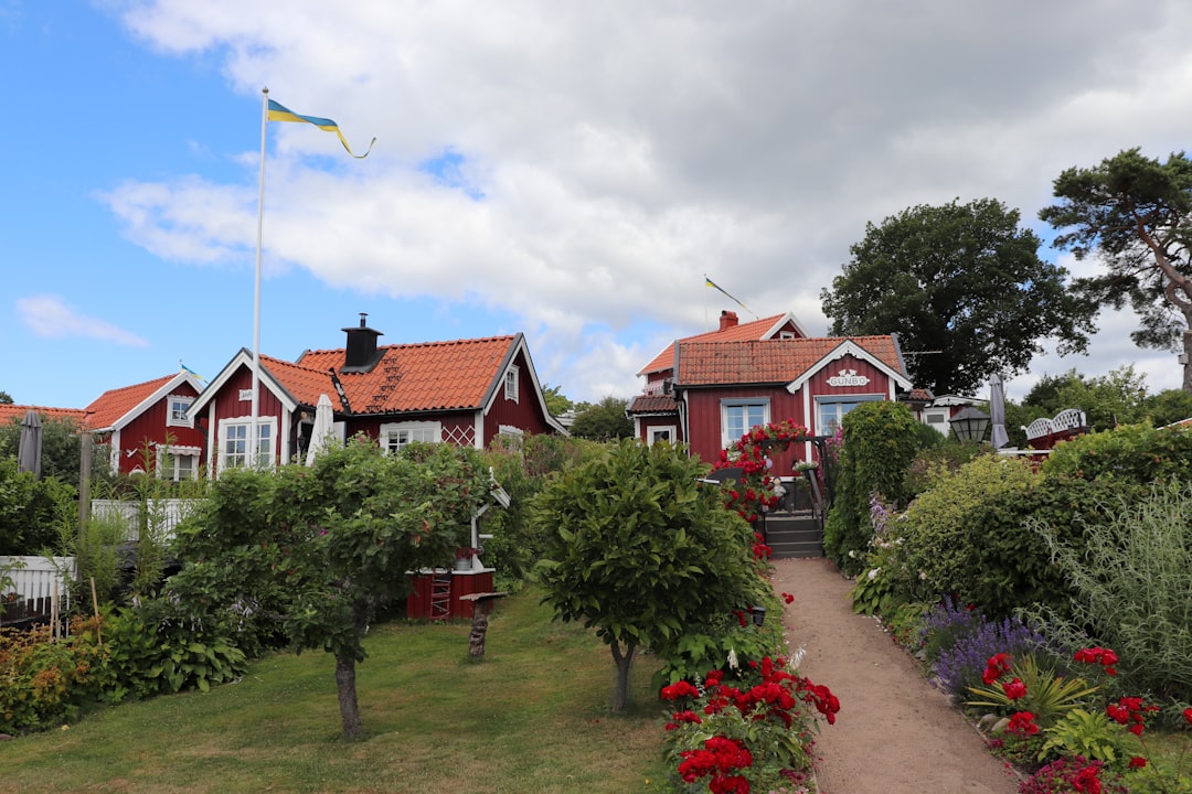 A red house surrounded by flowers and trees,