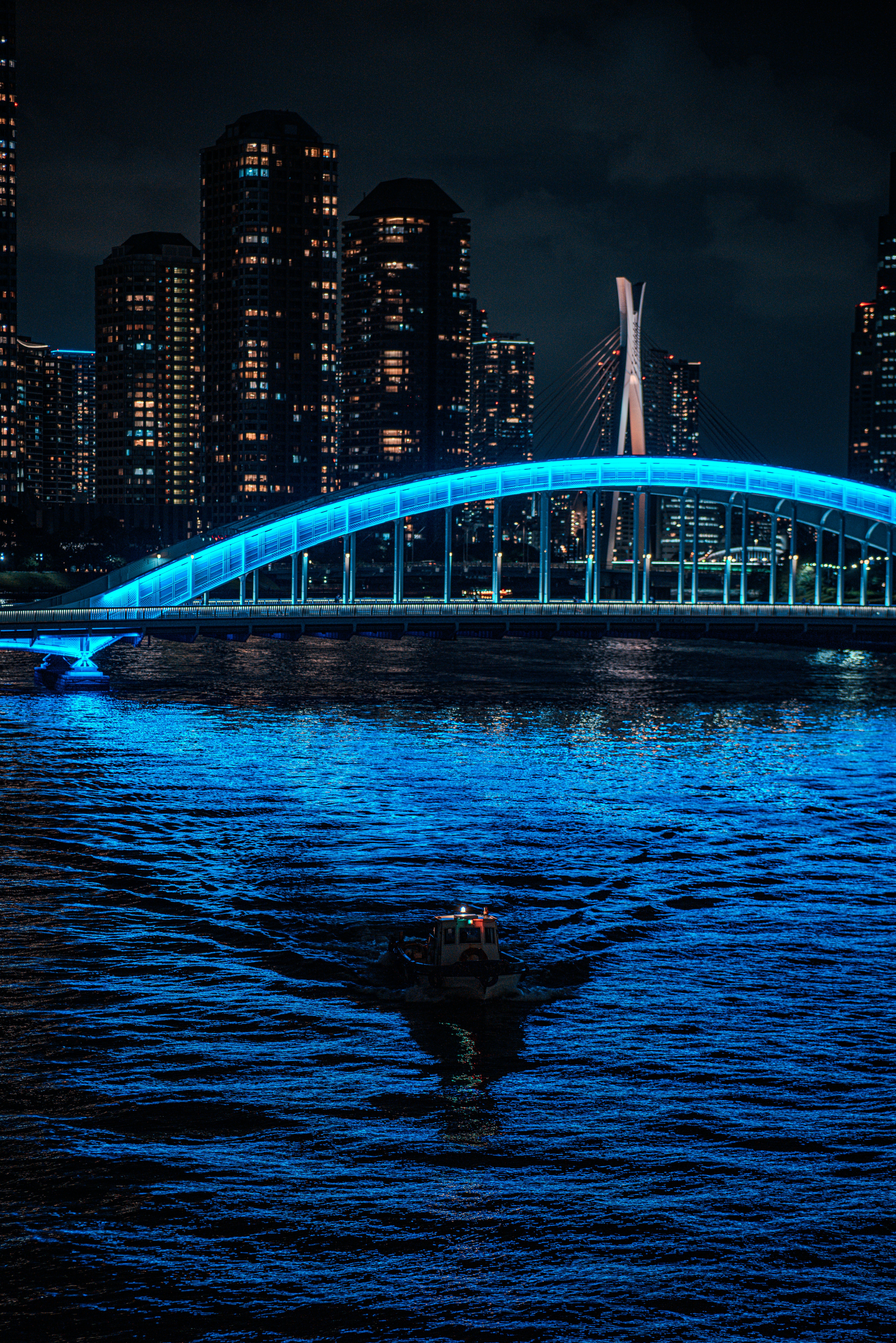 A boat in a body of water with a bridge in the background