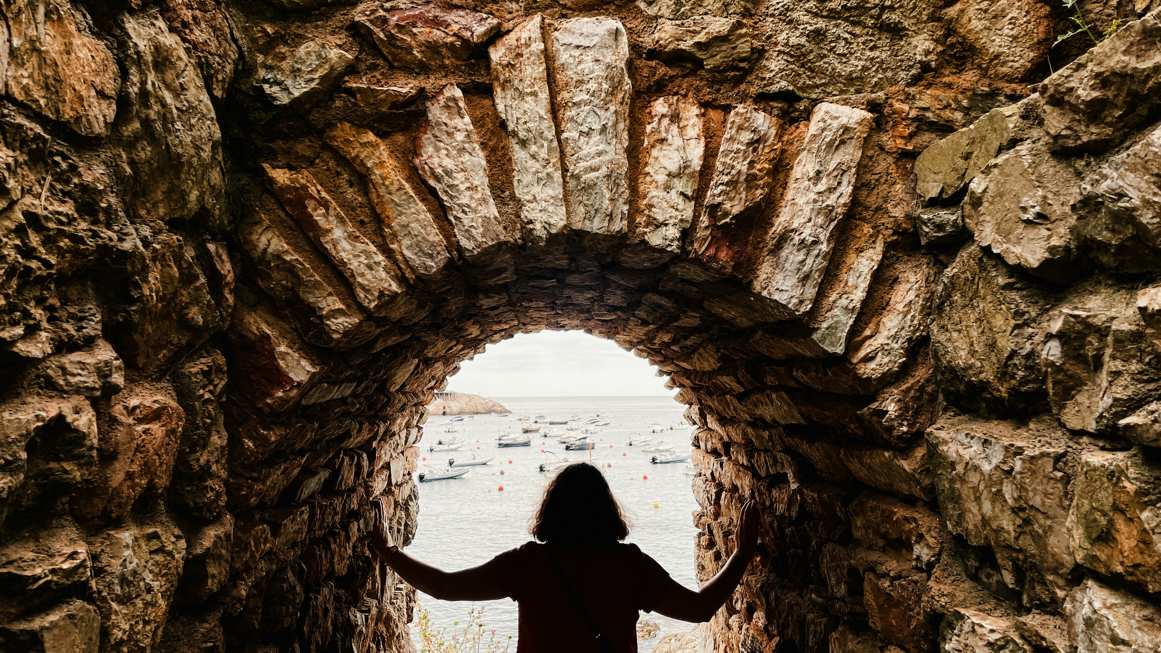 A person standing in a tunnel with their arms outstretched