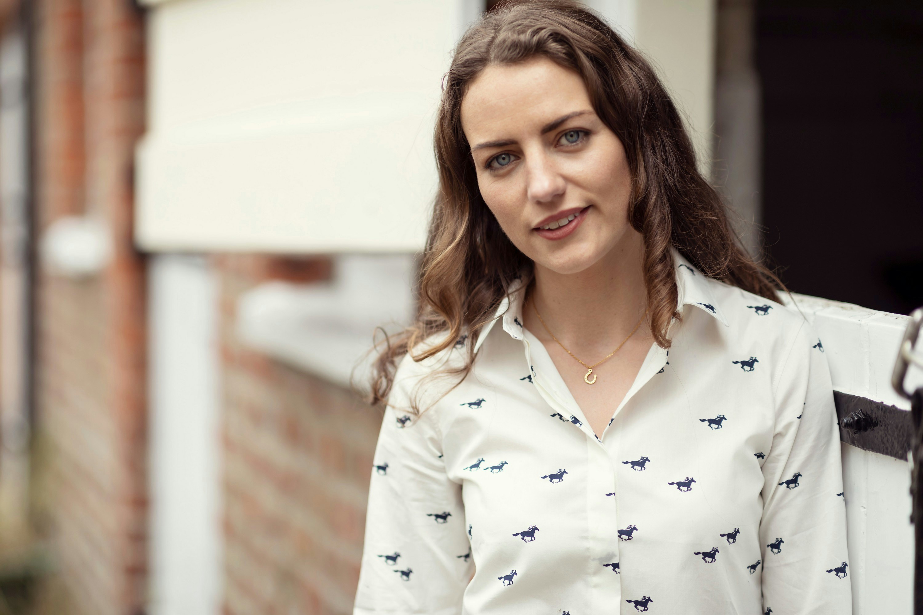 Una donna in camicia bianca è in piedi fuori