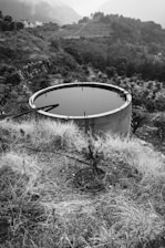 A large water tank sitting on top of a dry grass field