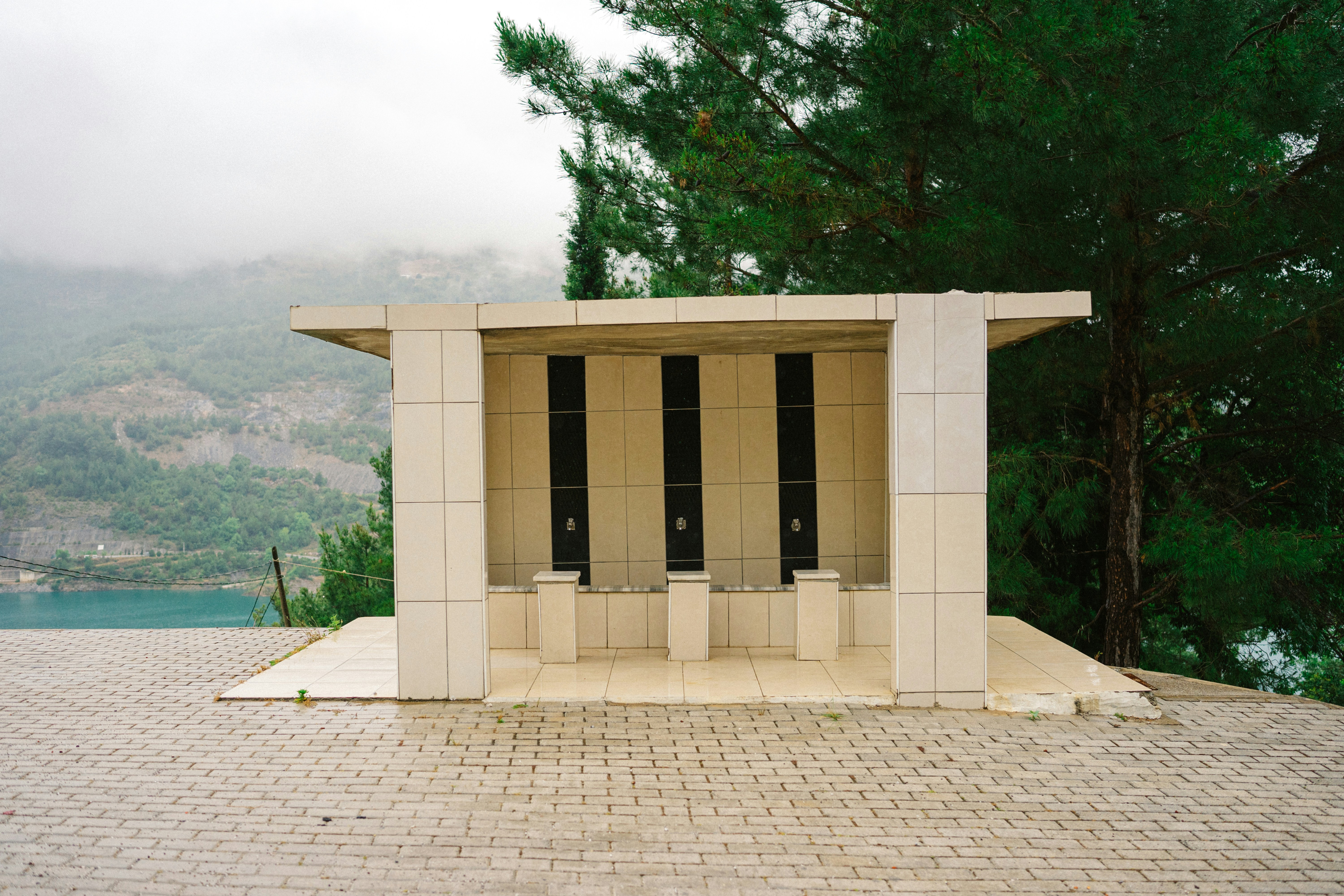 A small white structure sitting on top of a brick road