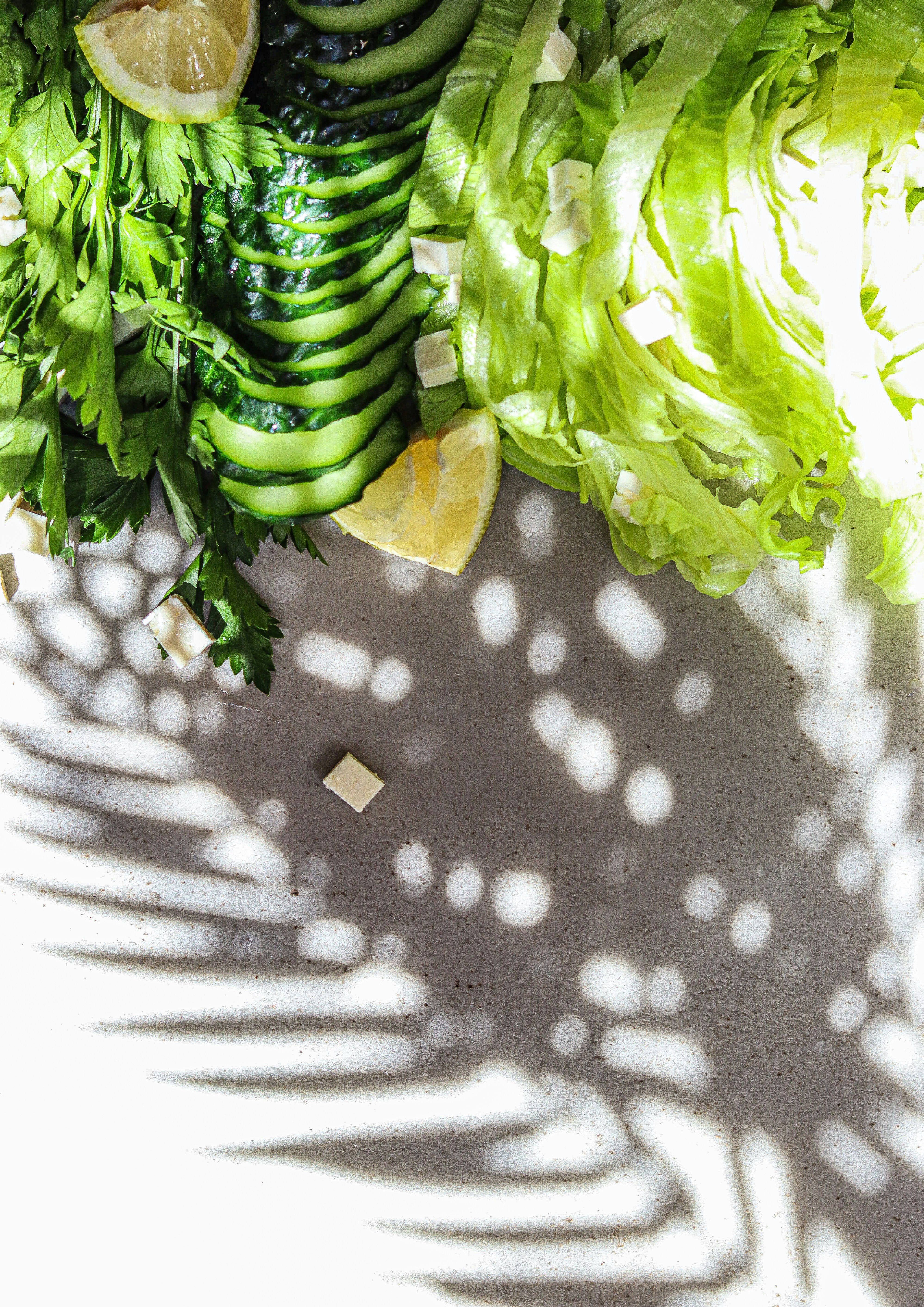 Lechuga, limón y perejil sobre una superficie blanca