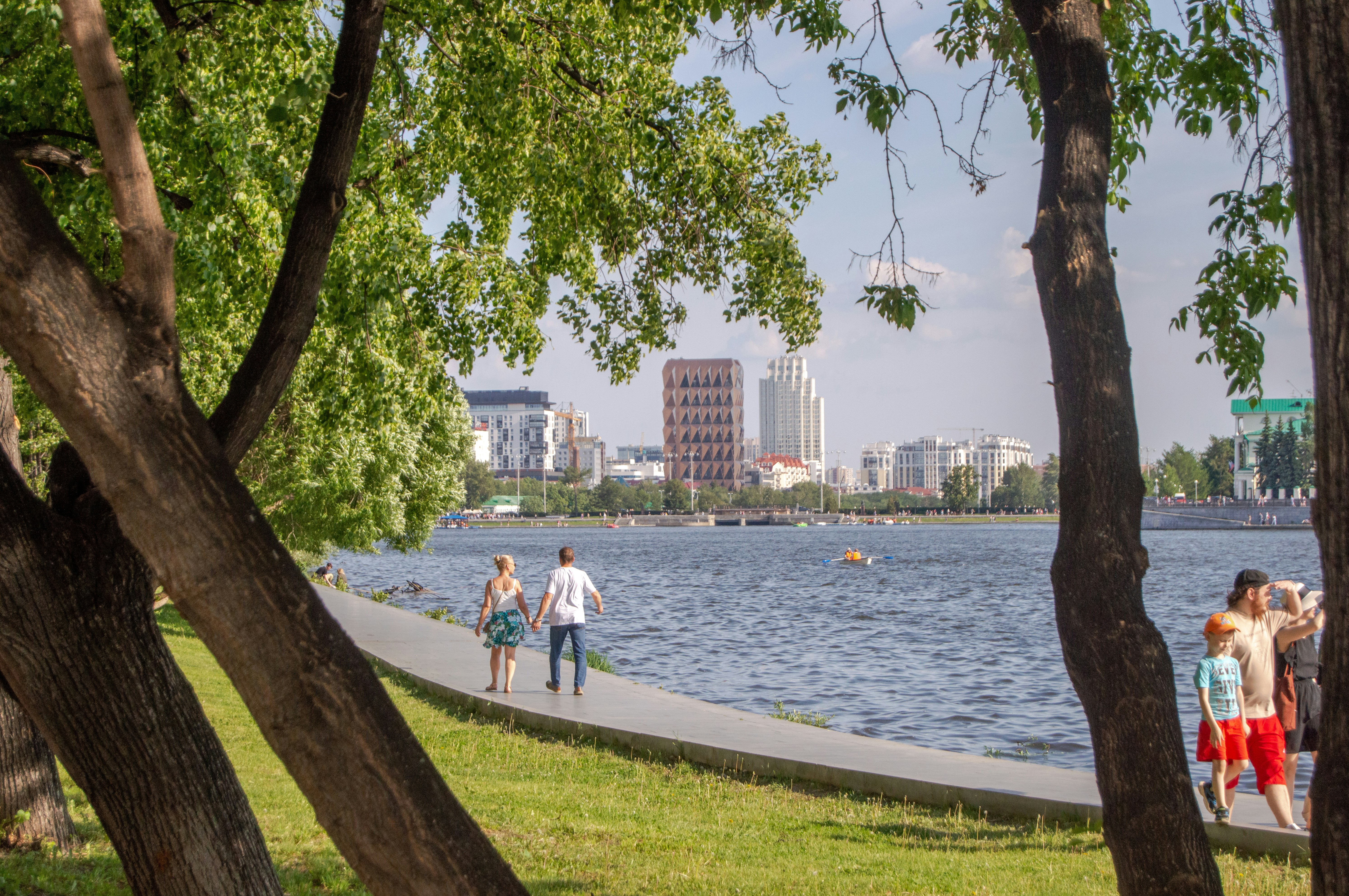 A group of people walking on a path next to a body of water