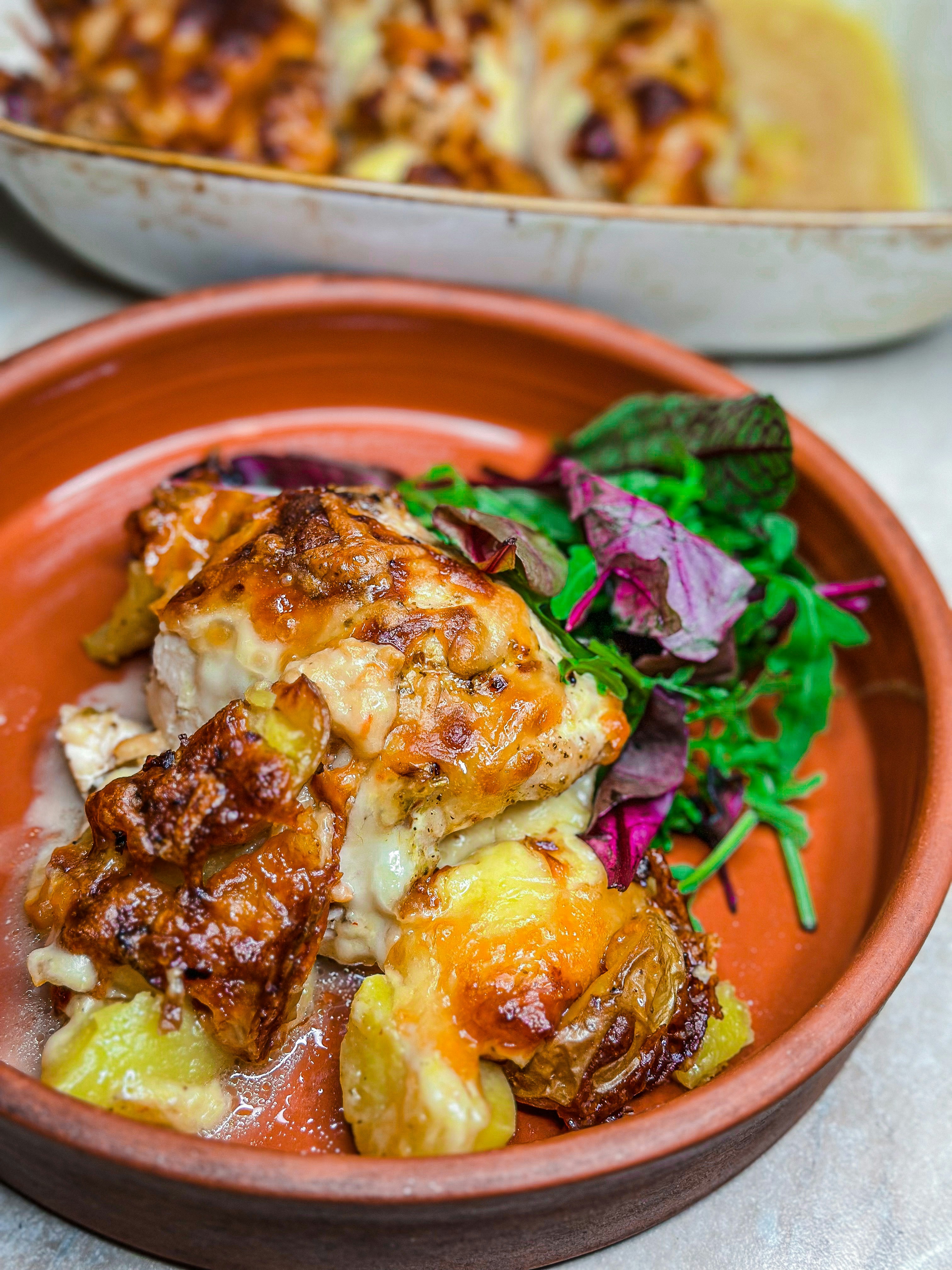A plate of food on a table next to a bowl of food