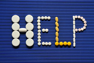 Pills spelling out the word pill pill on a blue background
