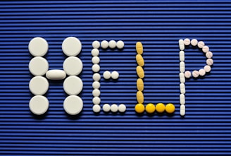 Pills spelling out the word pill pill on a blue background