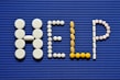 Pills spelling out the word pill pill on a blue background