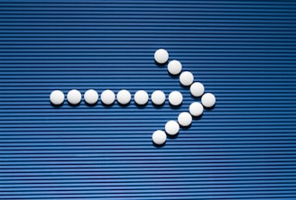 Pills are arranged in the shape of a cross on a blue background