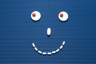 A smiley face made out of pills on a blue background