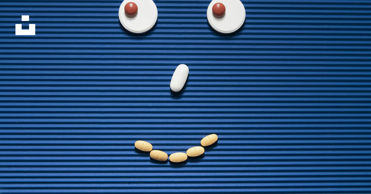 A sad face made out of pills on a blue background photo – Free Health ...