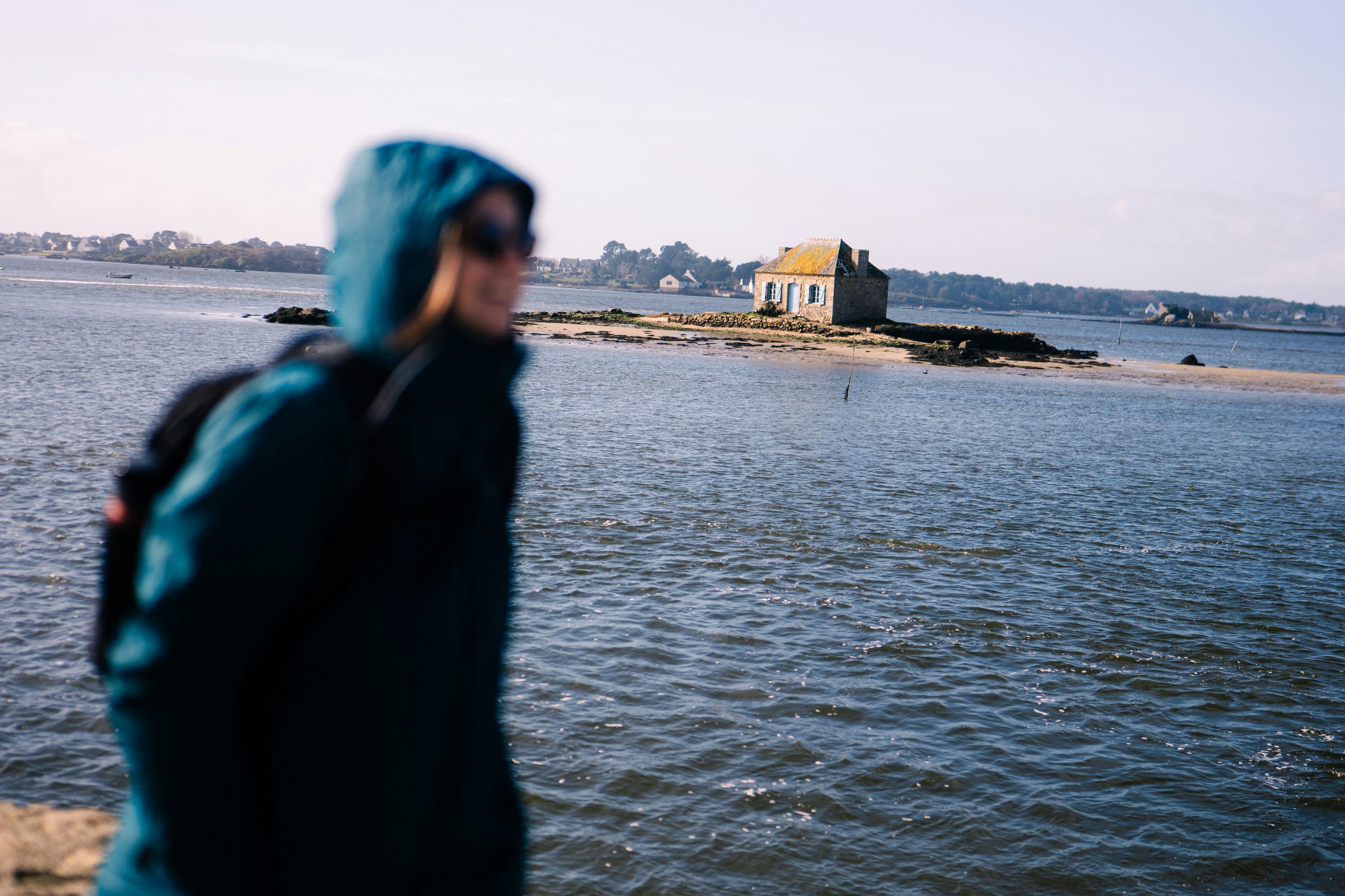 A woman in a blue jacket looking out at the water