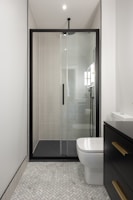 A bathroom with a toilet, sink, and shower