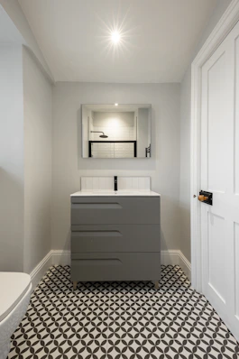 A bathroom with a toilet, sink and mirror
