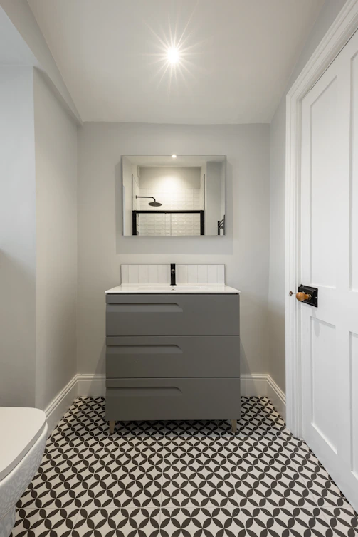A bathroom with a toilet, sink and mirror