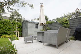 A patio with a table and chairs and an umbrella