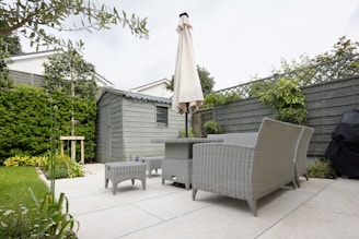 A patio with a table and chairs and an umbrella