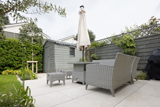 A patio with a table and chairs and an umbrella