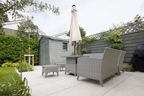 A patio with a table and chairs and an umbrella