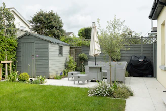 A backyard with a table and chairs and an umbrella