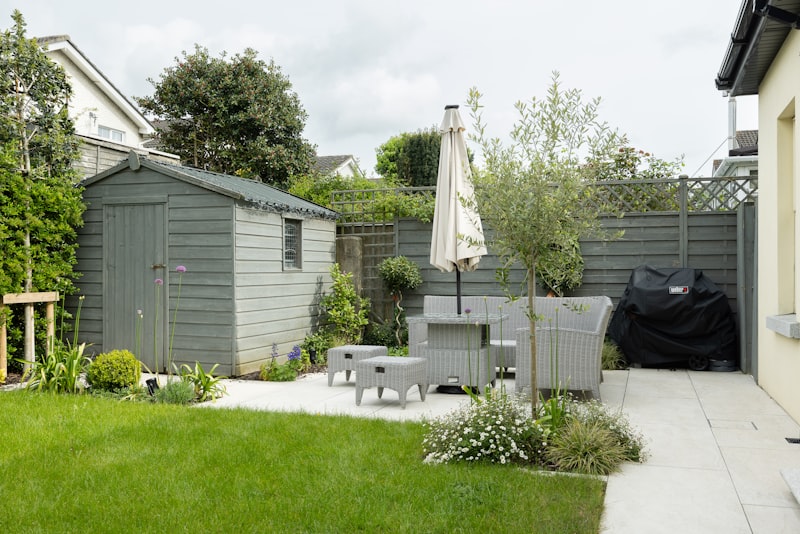 After: professionally landscaped backyard with patio seating and planted beds
