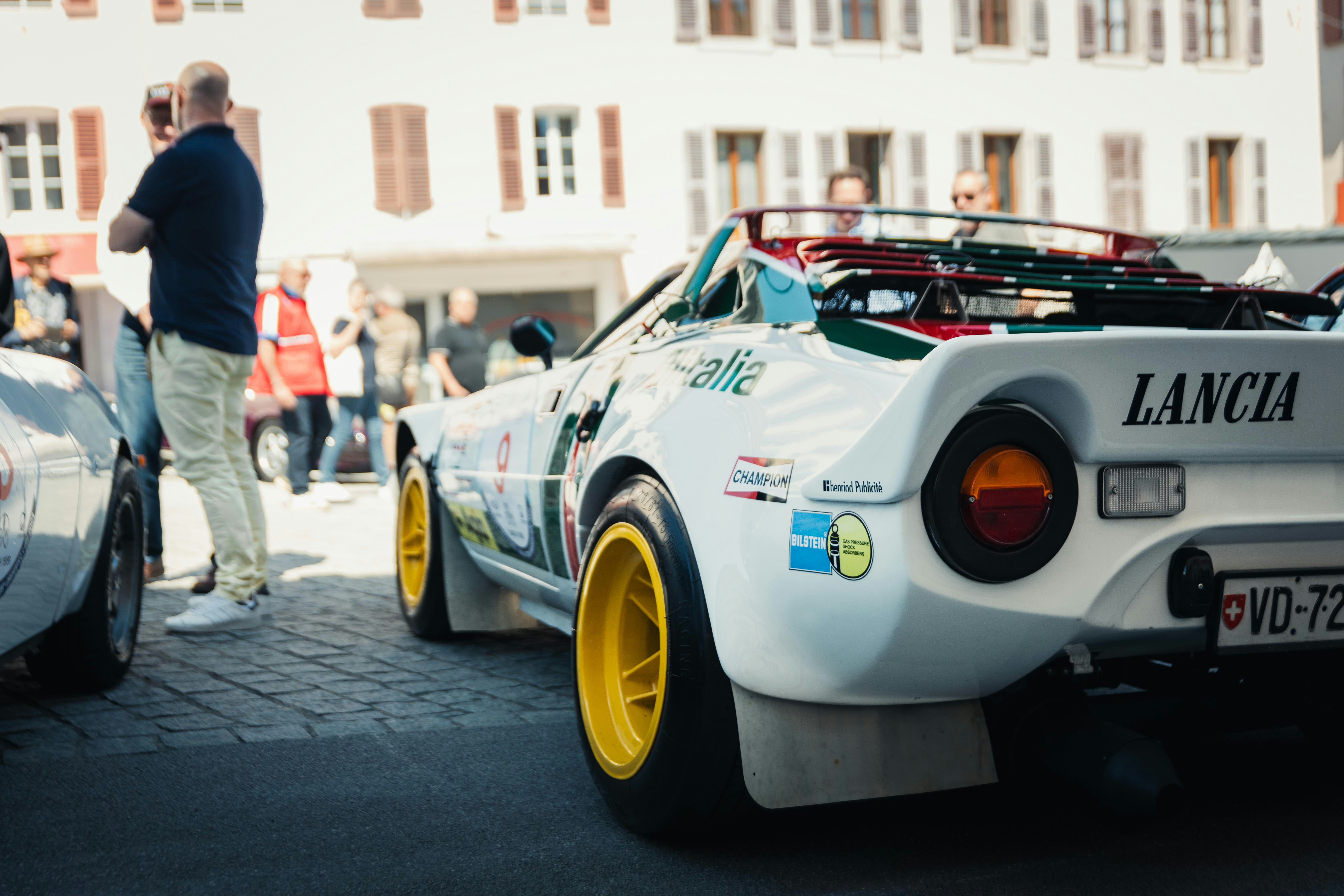 A man standing next to a white sports car