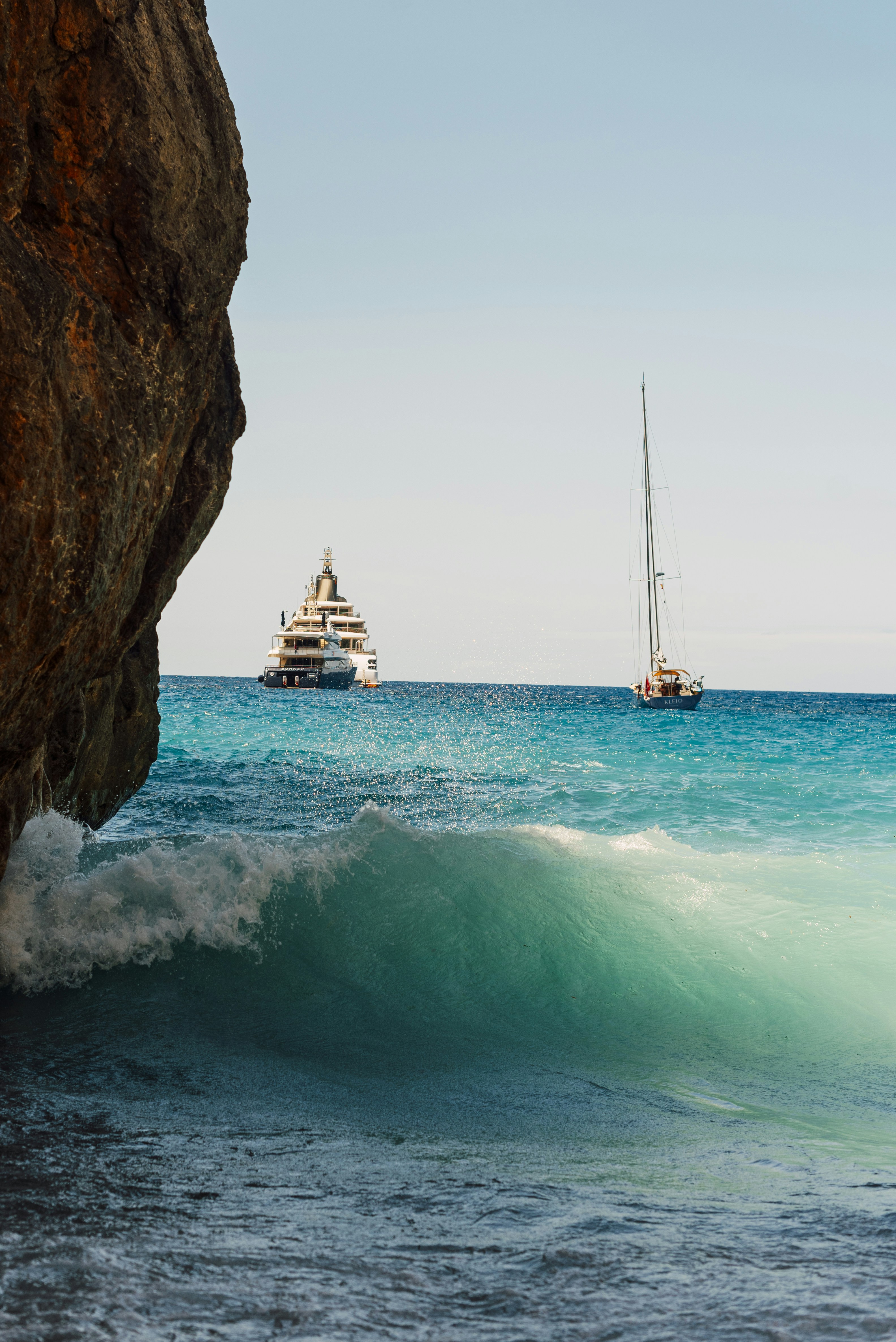 A boat is in the water near a cliff