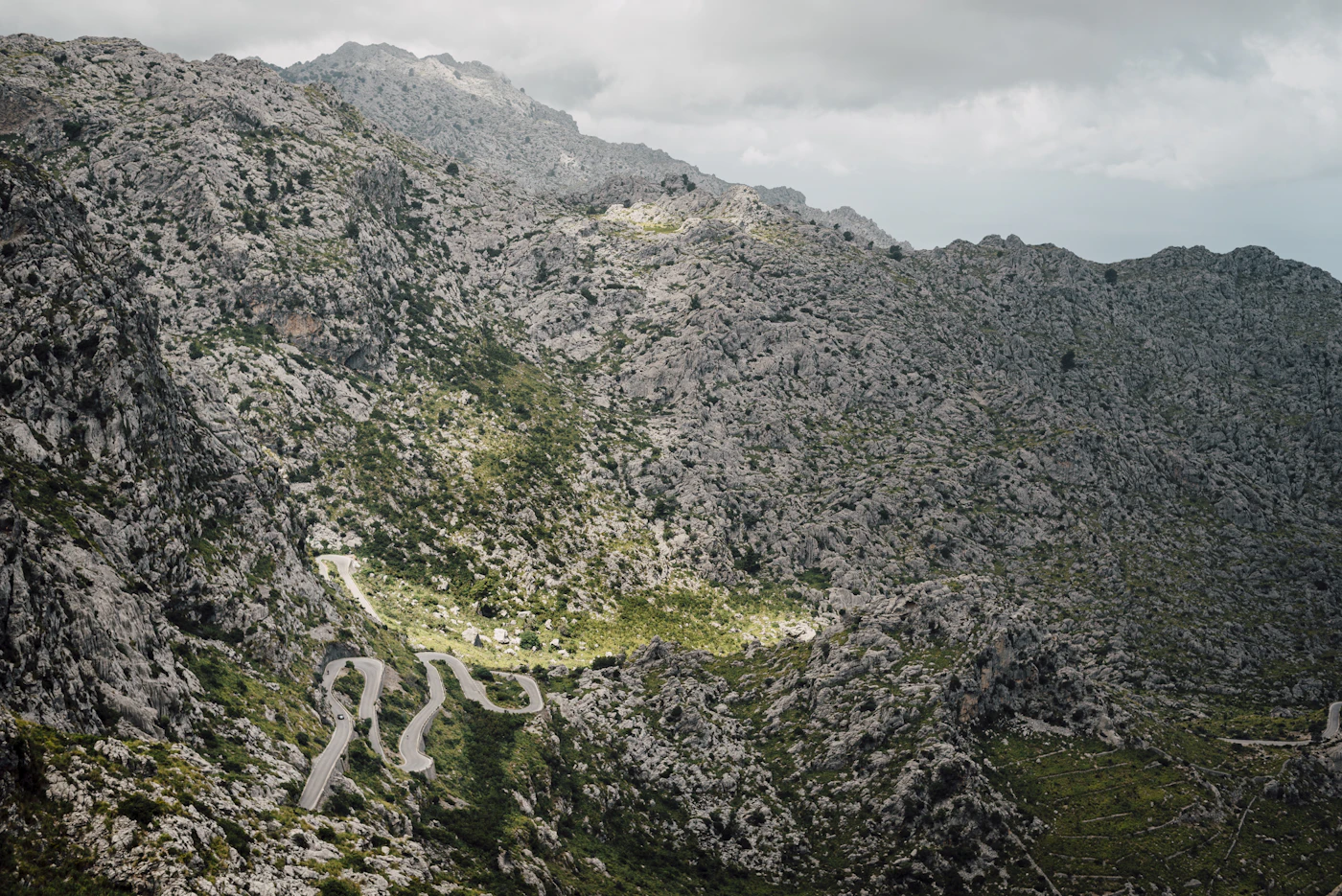 La route MA-2141 serpentant en virages serrés sur un flanc de montagne calcaire en direction de Sa Calobra.