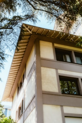 A tall white building sitting next to a tree