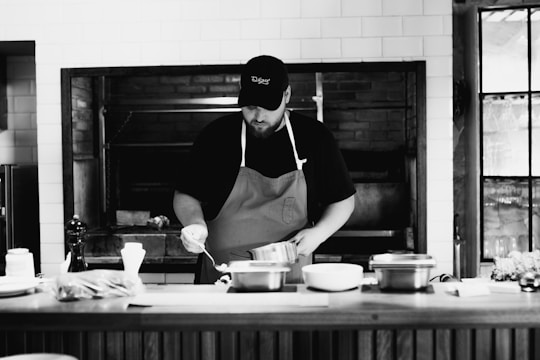 A man in an apron is cooking in a kitchen