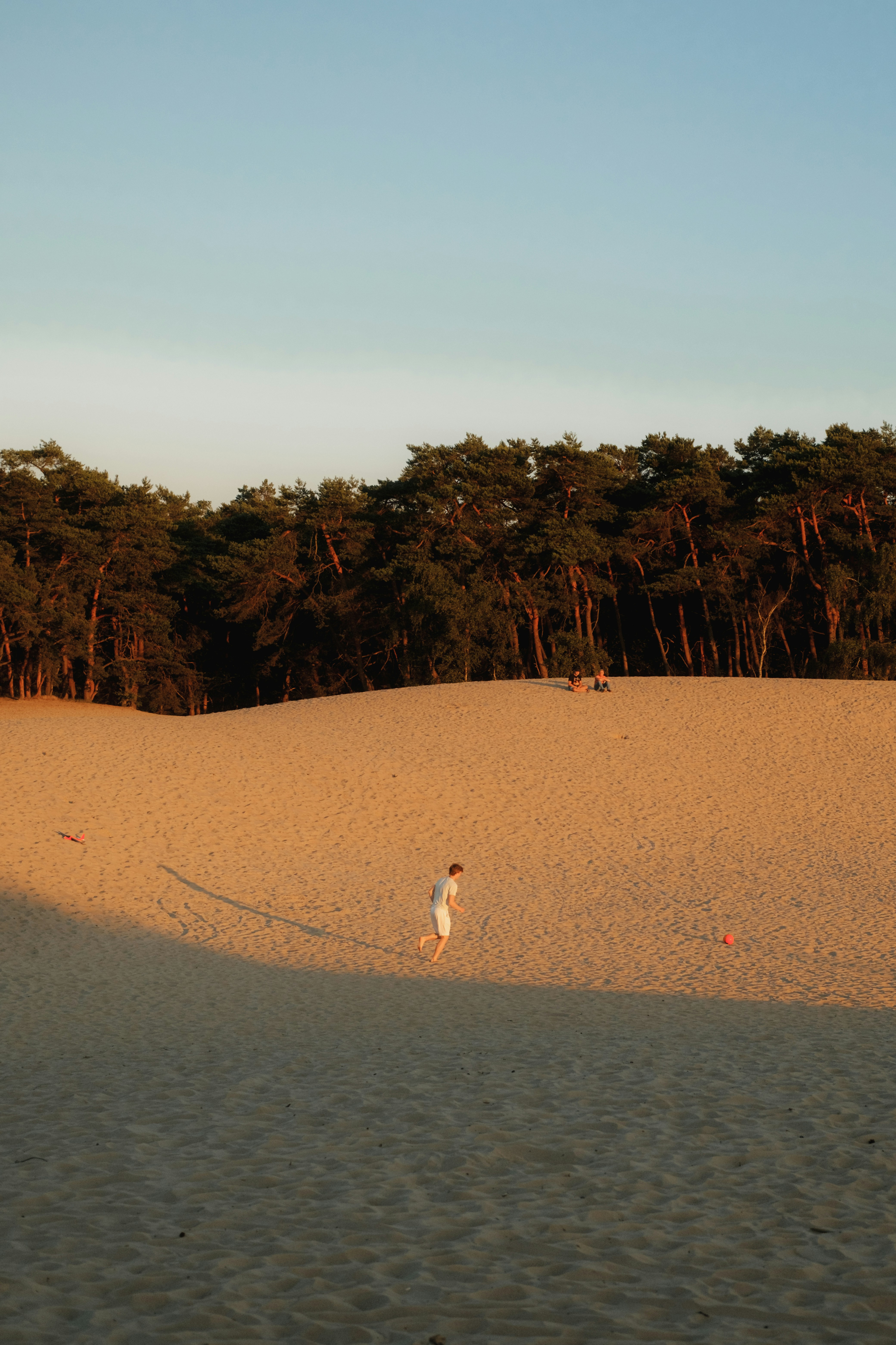A person flying a kite on a sandy beach