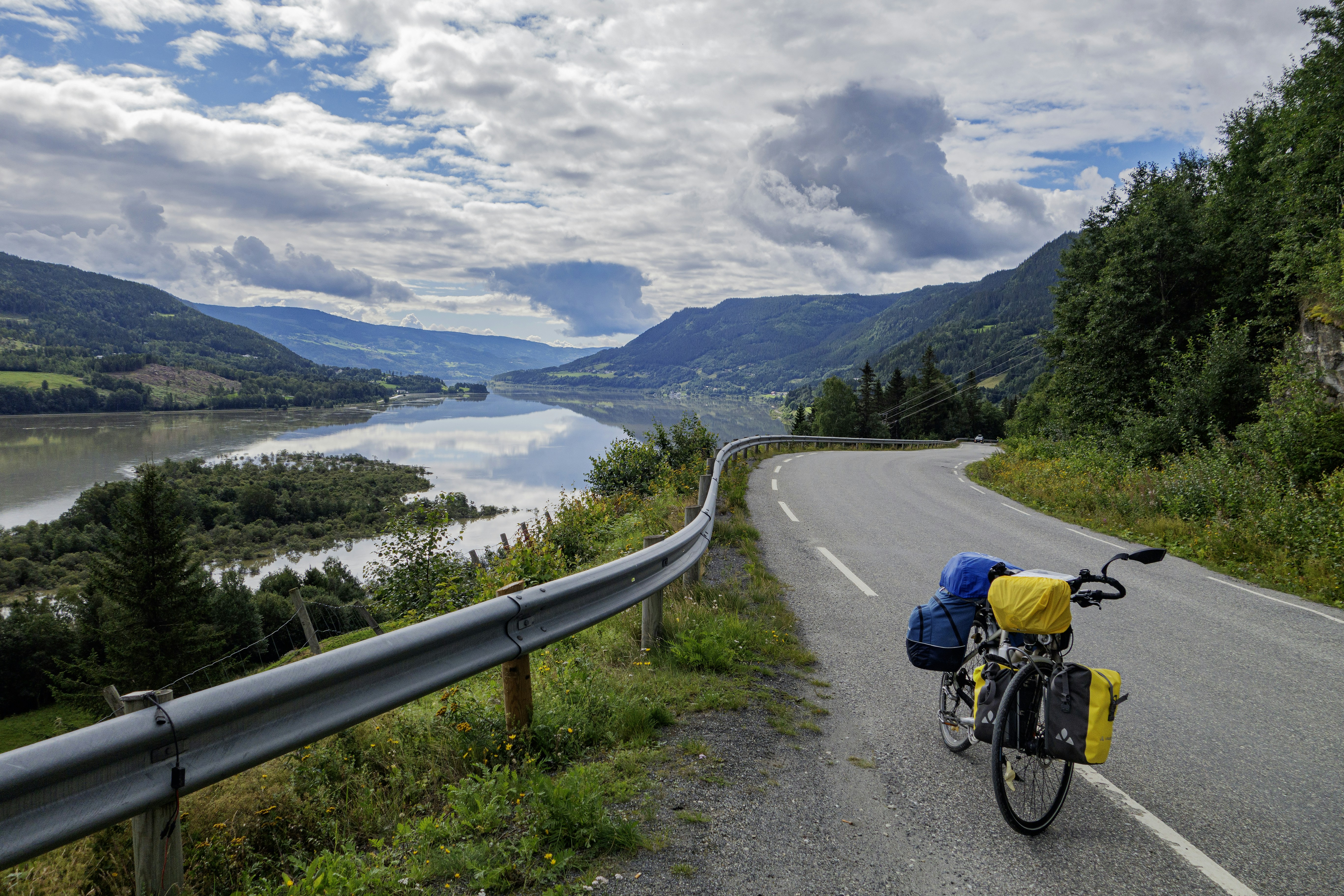 A bike parked on the side of a road next to a lake