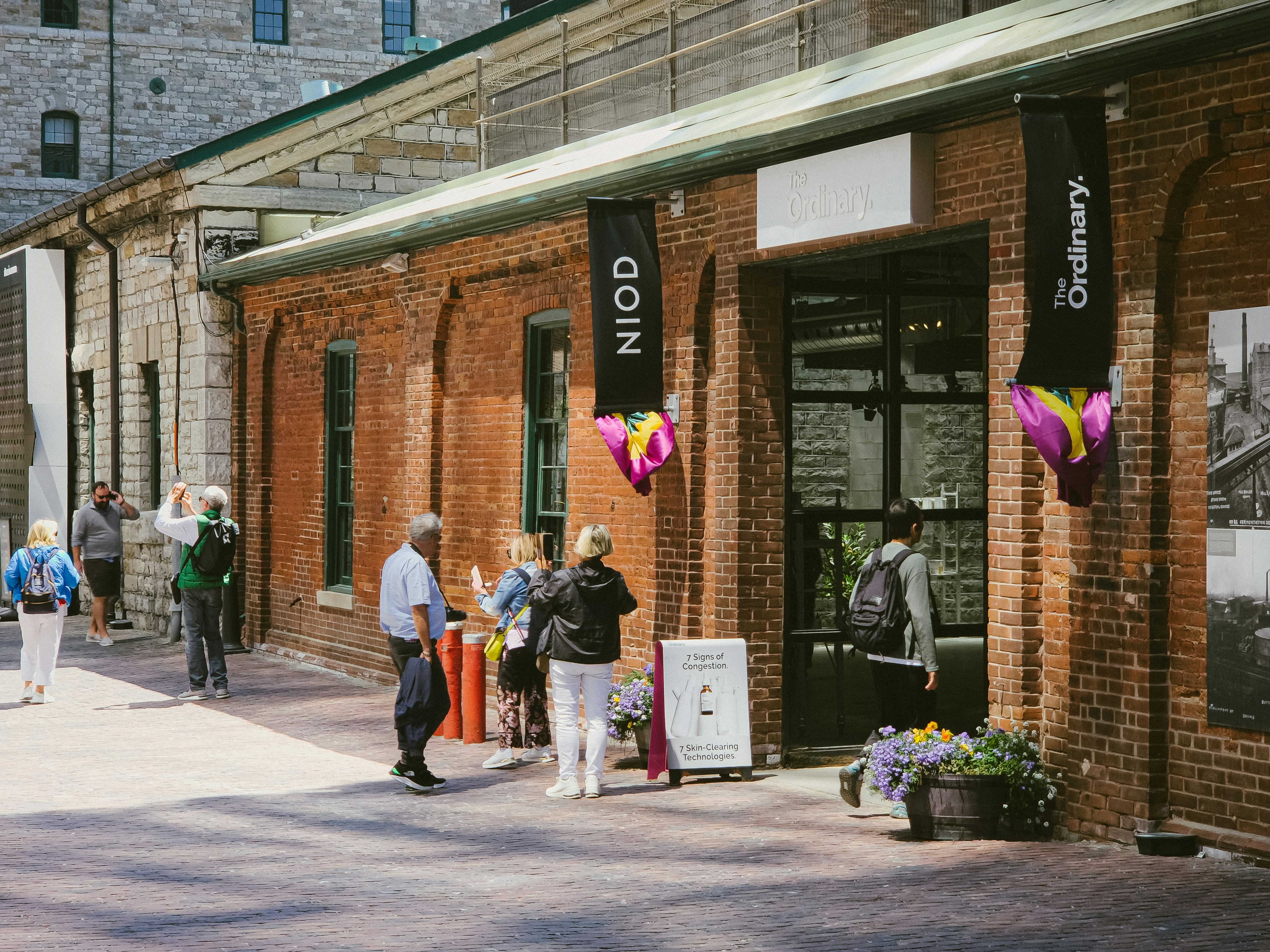 A group of people standing outside of a building, Distillery District