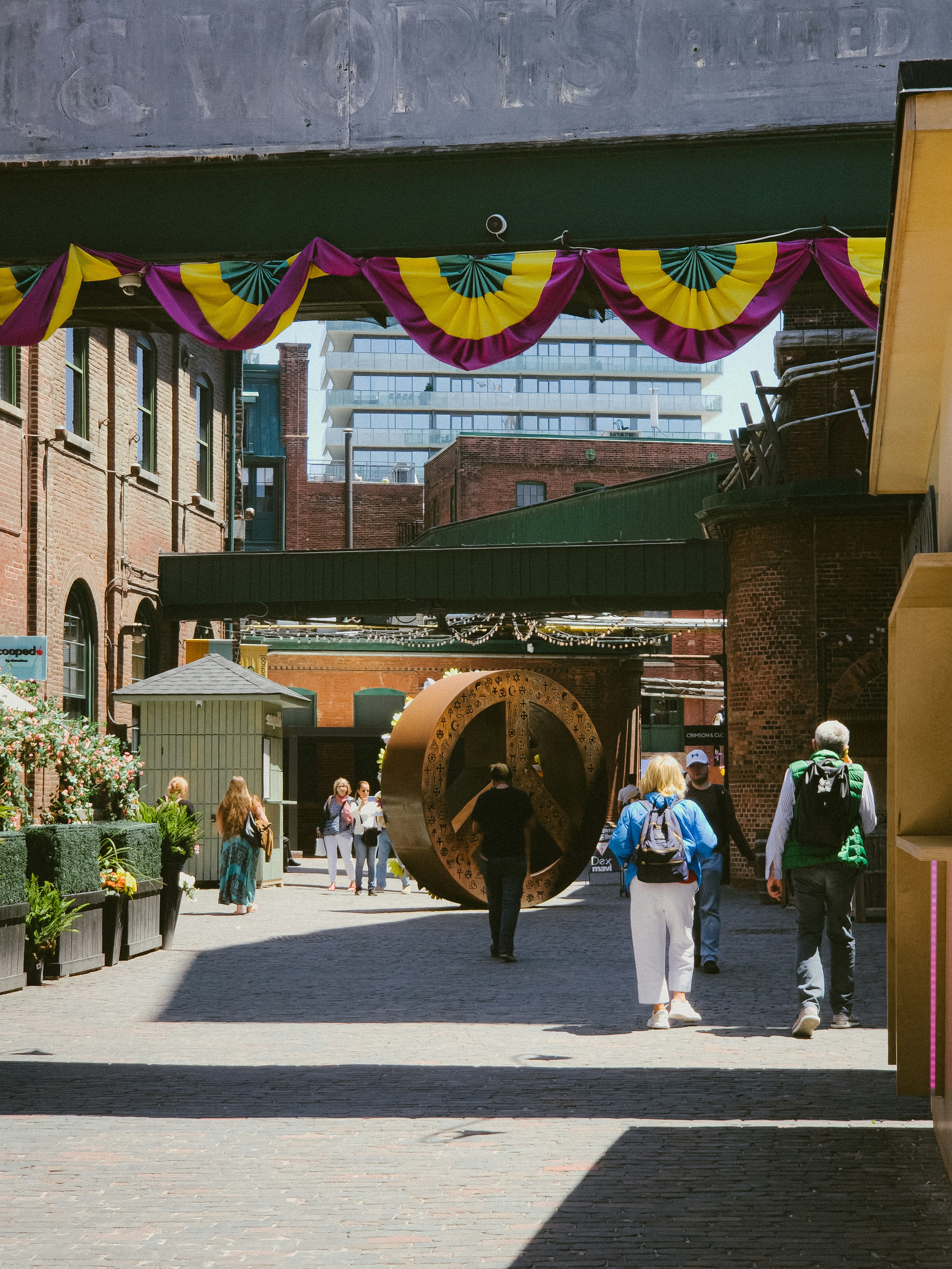 A group of people walking down a street next to tall buildings
