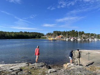 A couple of people standing on top of a rocky shore