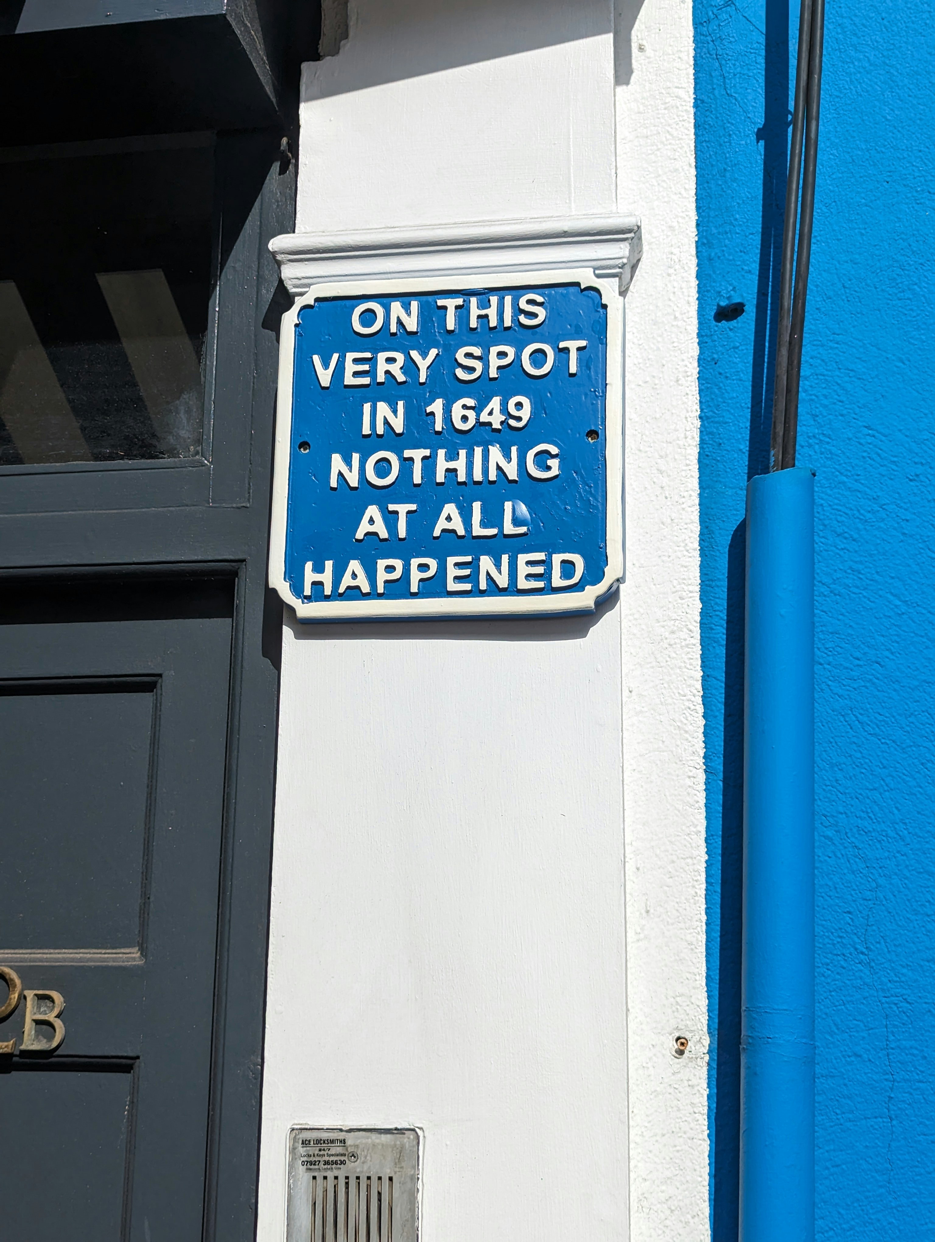 A blue and white sign on the side of a building