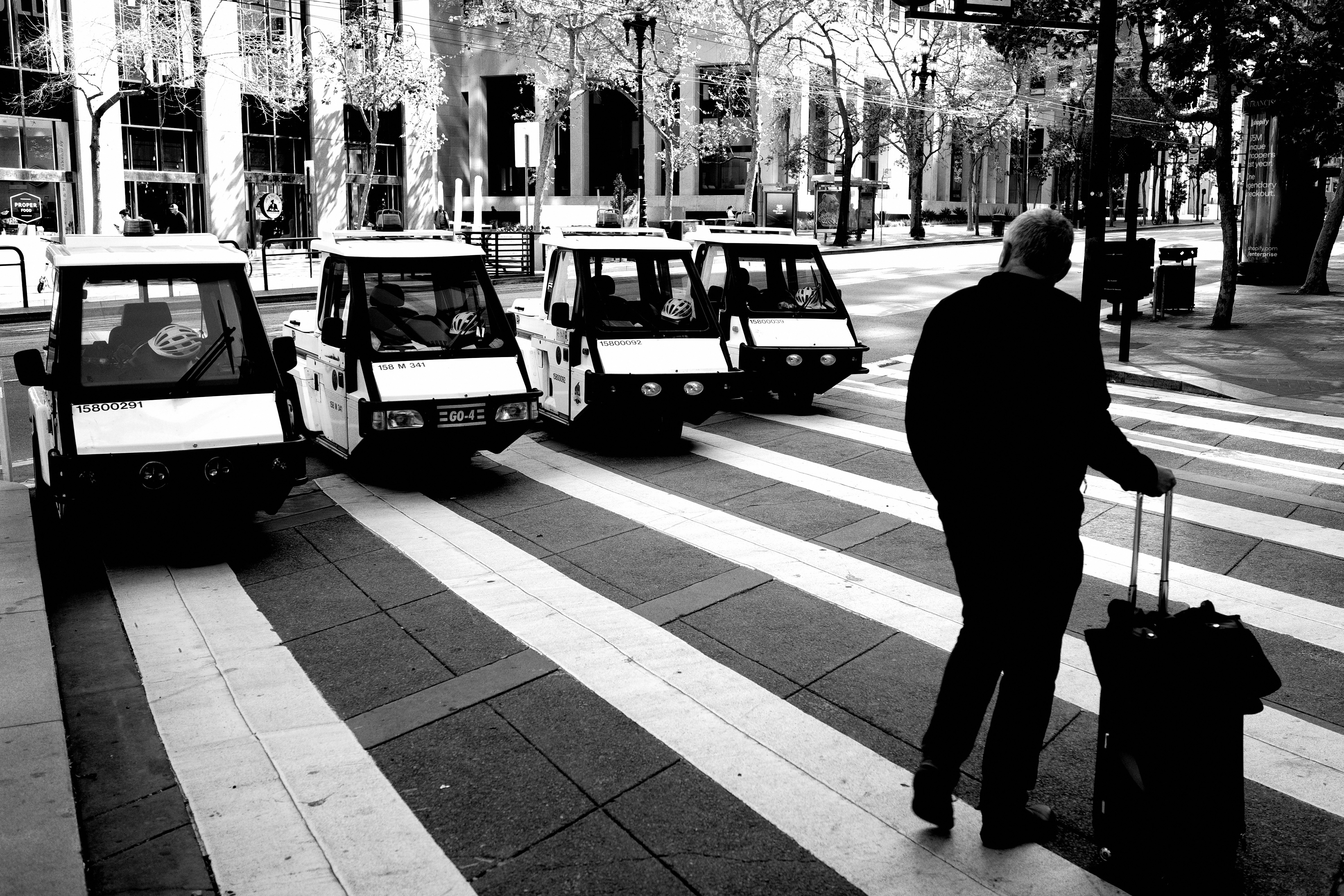 A black and white photo of a man pulling a suitcase