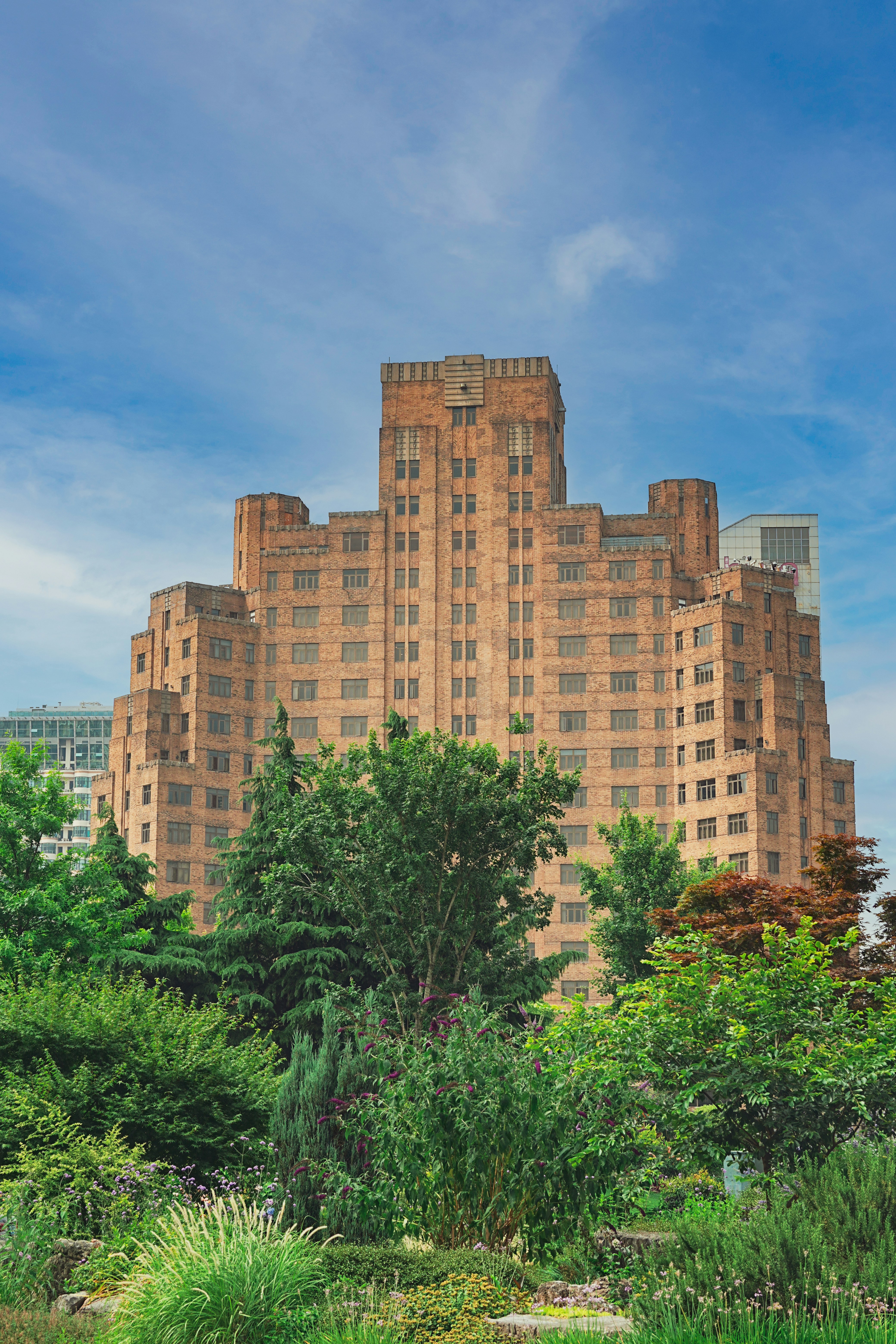 A very tall building sitting in the middle of a lush green park