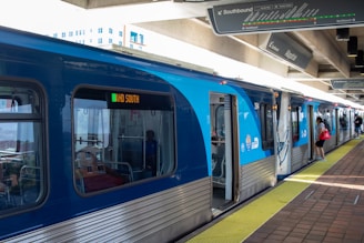 A blue and silver train at a train station