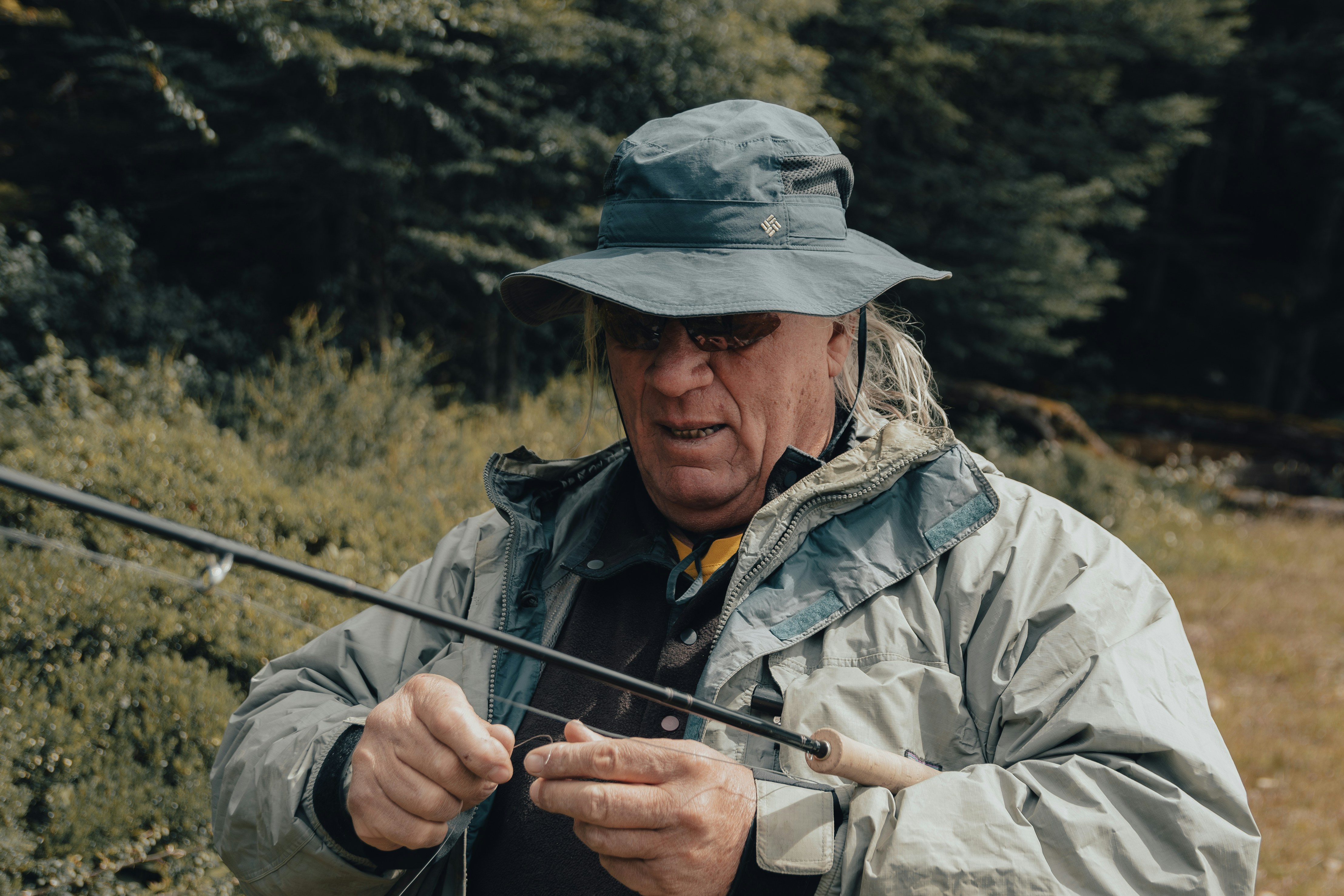 A man in a hat holding a fishing rod