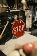 A red stop sign sitting on top of a floor