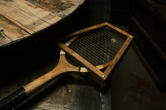 A tennis racket sitting on top of a wooden table