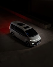 A white van parked in a parking lot at night