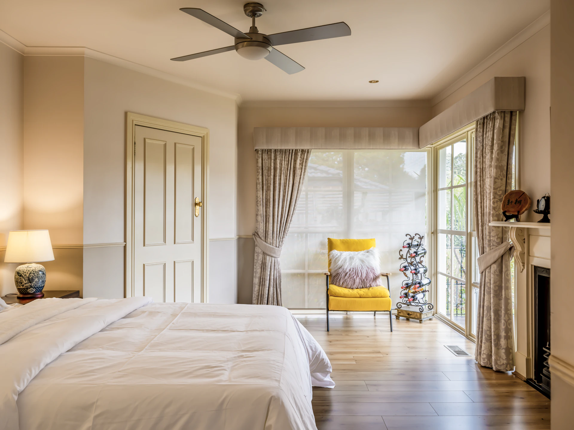 A bedroom with a large bed and a ceiling fan
