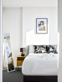 A bedroom with a bed and a mirror