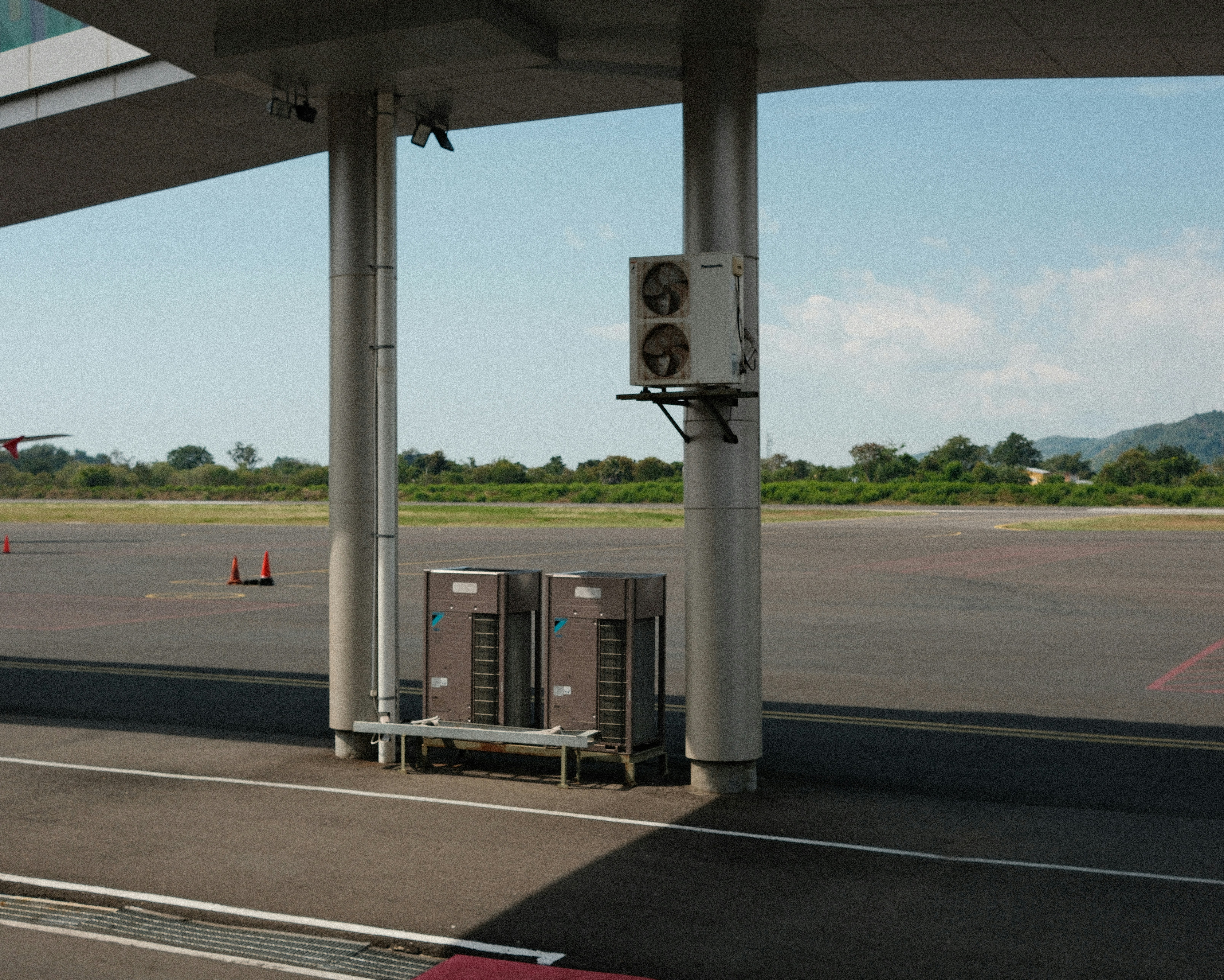 A gas station with a gas pump on the side of the road, 