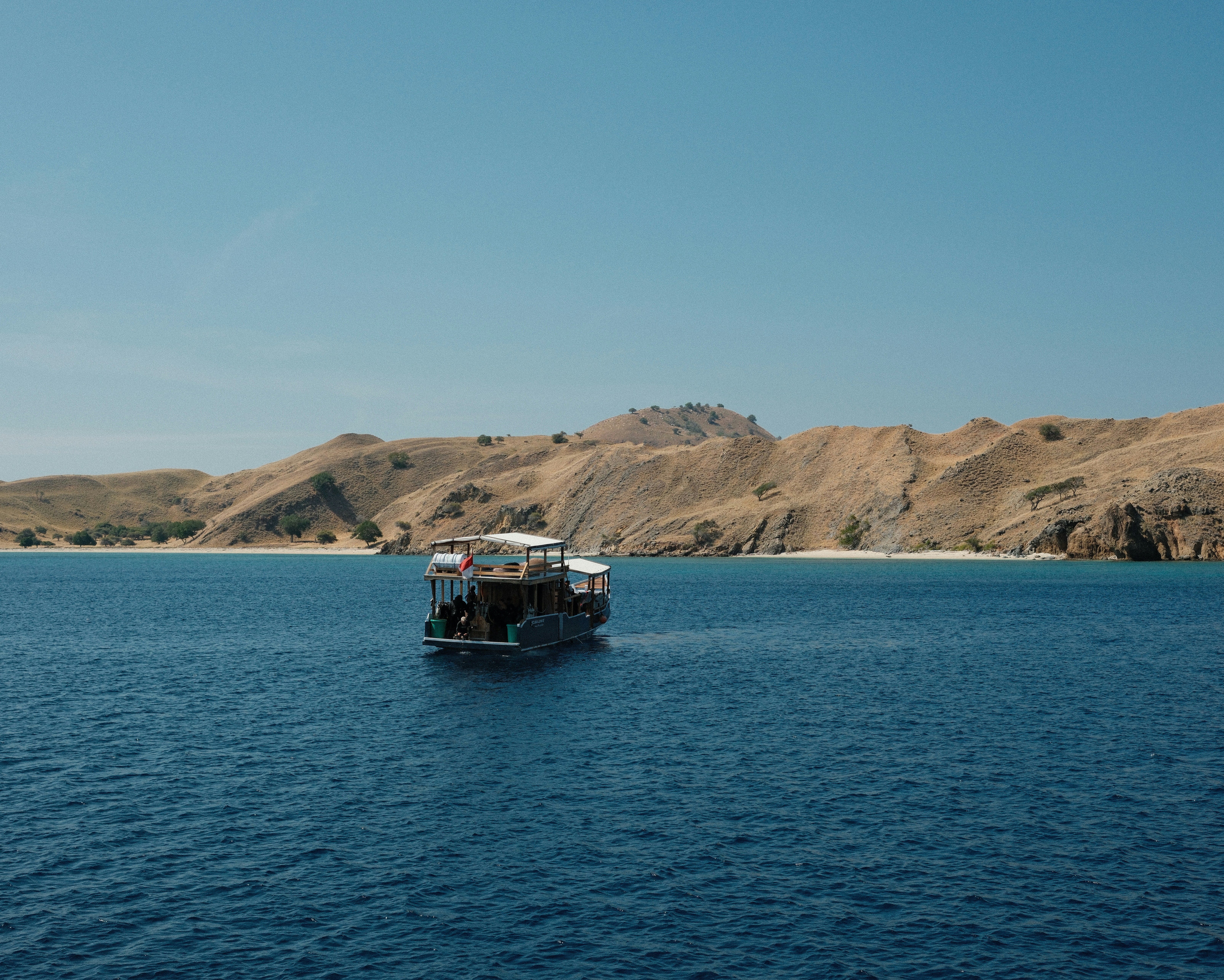 A small boat in the middle of a large body of water
