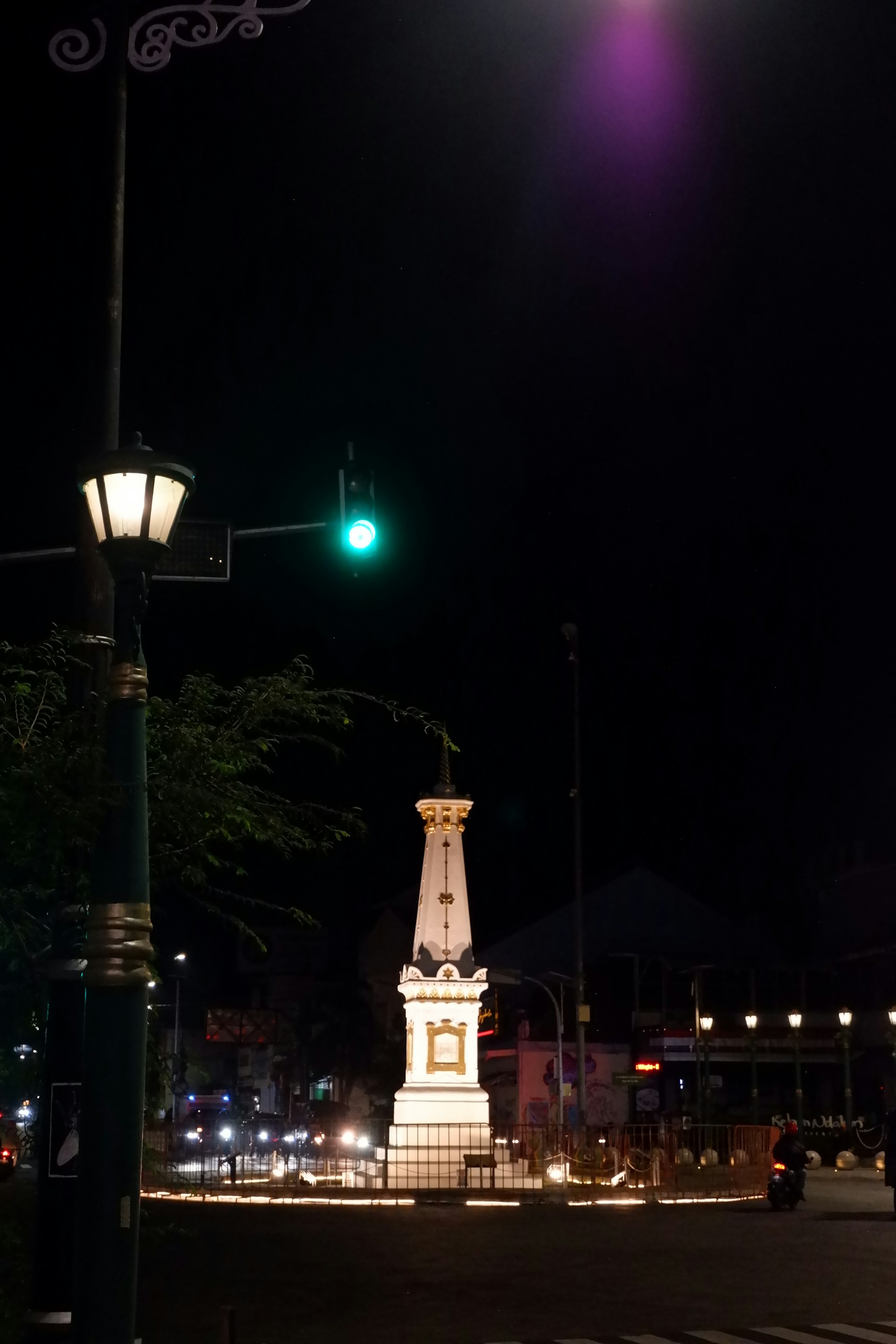 A street light with a clock tower in the background