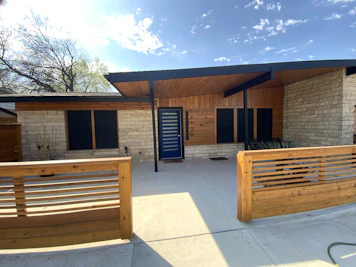 A house with a wooden fence and a blue door