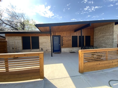 A house with a wooden fence and a blue door